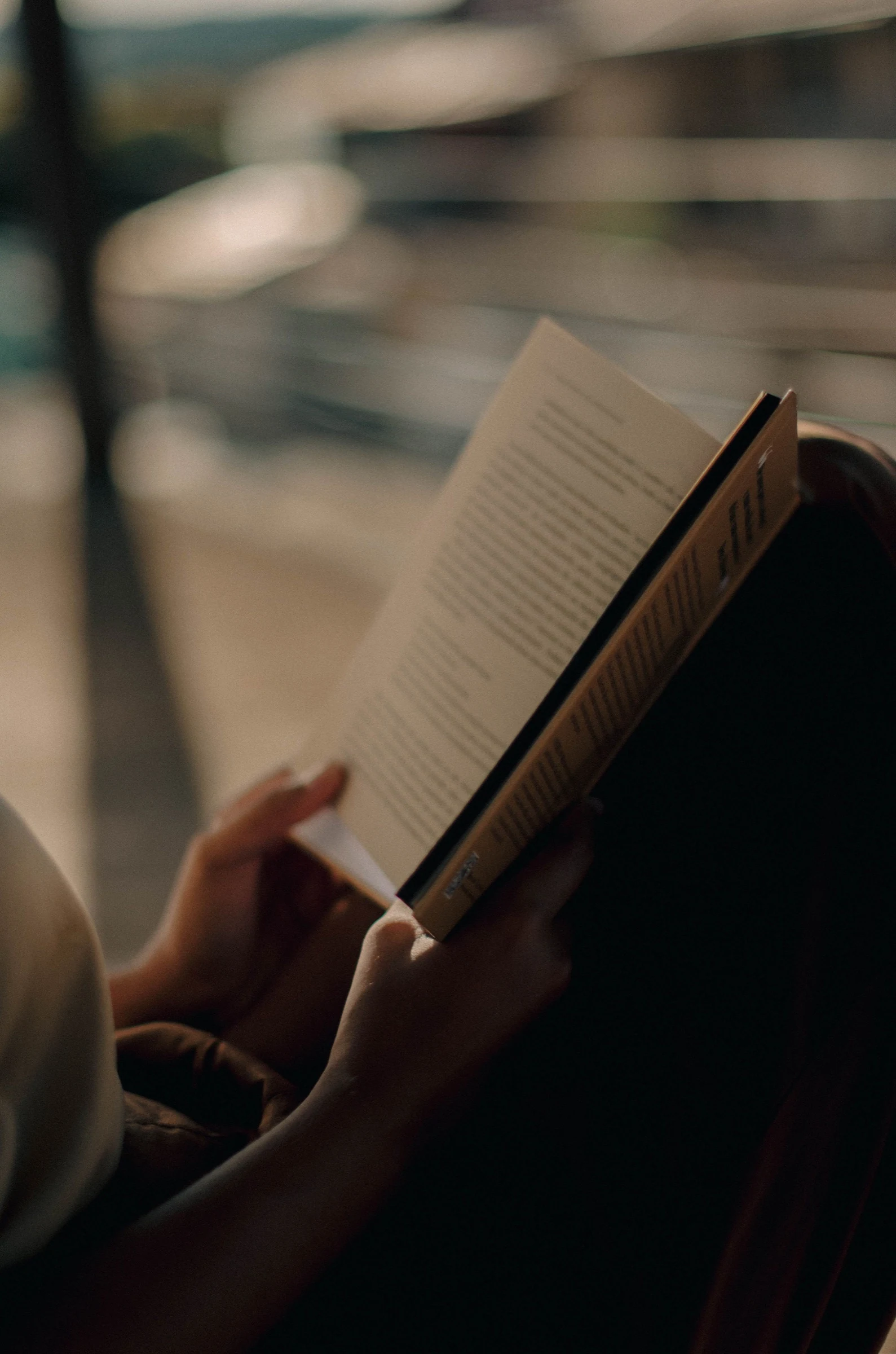 Pessoa lendo um livro em um ambiente urbano contemporâneo