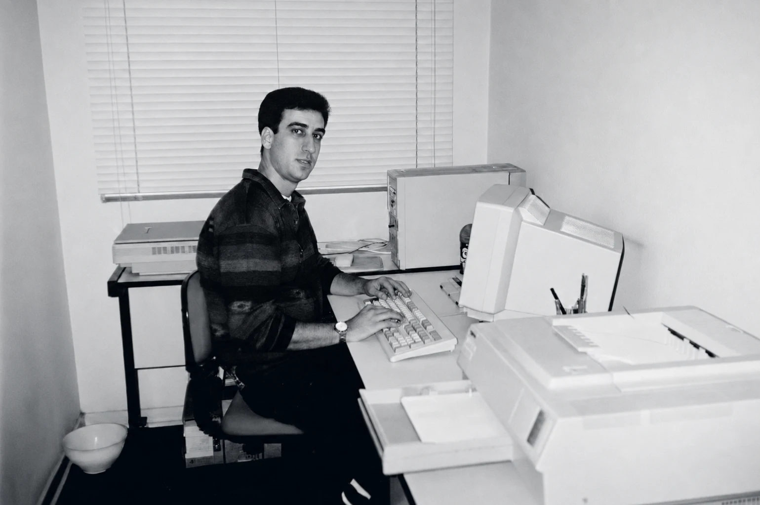 Marcelo Cardoso no início da gestão da Linotec, sentado diante de equipamentos de editoração eletrônica